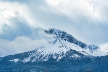 Majestic snowy rocky mountains with cloud flowing at countryside