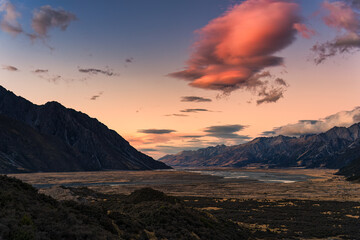 Sunrise over rocky mountain range on dry field in autumn
