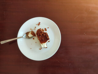 A plate of half-eaten cheesecake on the table. Negative space. Soft focus.