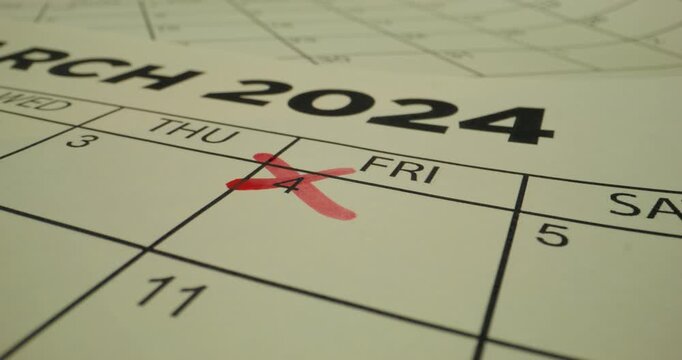 A person crosses out a number in the schedule table with a red marker. Close-up of the marker, an unrecognizable person