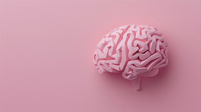 Paper model of brain on pink surface from above Room for text