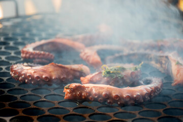 octopus tentacles grilling on hot coals with smoke © mario