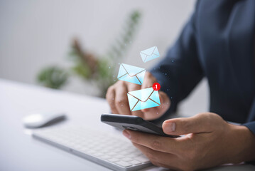 A person interacts with email notifications on a smartphone, indicating active communication and digital connectivity.