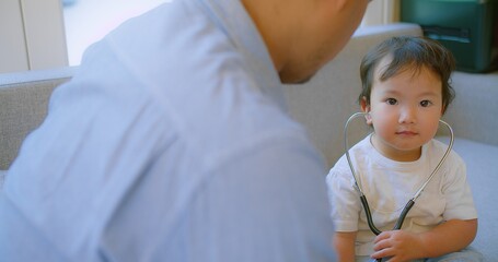 cute small child and father game as Doctor holding Stethoscope listening to father patient pretending nurse having fun with dad in cozy living room at home, capturing a heartwarming family moment.