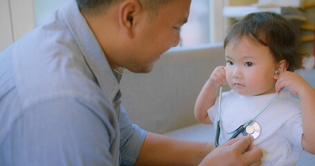 cute small child and father game as Doctor holding Stethoscope listening to father patient pretending nurse having fun with dad in cozy living room at home, capturing a heartwarming family moment.