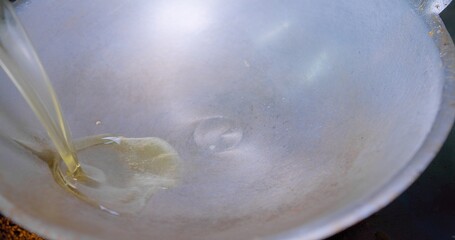 Close-up view of oil being poured into a hot wok with smoking ready for cooking, Close-Up View of...