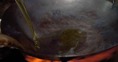 Close-up view of oil being poured into a hot wok with smoking ready for cooking, Close-Up View of...