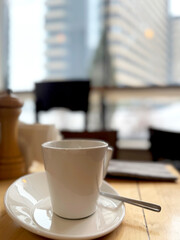 white coffee cup and saucer on the table on a blurred background