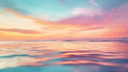 Obraz premium Colorful sunset over calm ocean waters with a soft, pastel sky