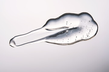 A smear of cosmetic gel close-up on a gray background. Appetizing texture with bubbles.