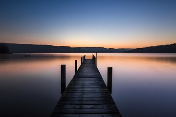 Serene twilight over a tranquil lake pier at dusk.