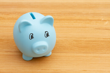 Saving money with a blue piggy bank on a desk