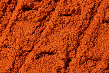Ground paprika, red terracotta spice background, art in cooking.