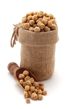Close-up of Organic Soya Chunks (Glycine max), in a jute bag and on a scoop, Isolated on a white background.