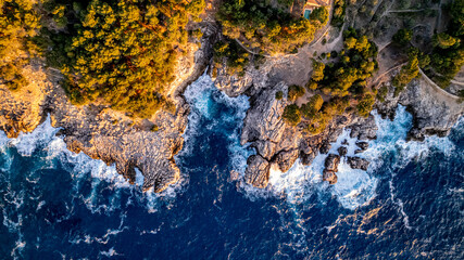drone aerial view sunset over rocky hill in Deia in Mallorca on a hot summer day