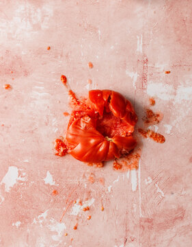 Crushed tomato on off-pink background. 