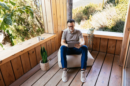 Mature man using tablet on terrace
