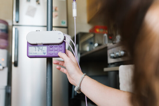 A woman adjusting a feeding pump machine