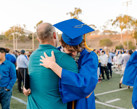 Father hugs son at graduation