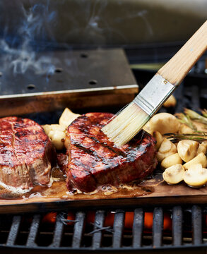 filet mignon steak cooking on a wood board on bbq