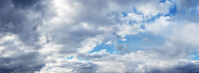 Obraz premium White and gray rain clouds cover the blue sky