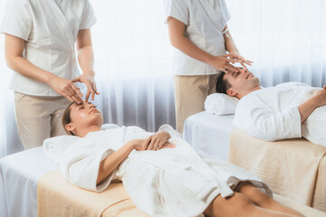 Obraz premium Caucasian couple enjoying relaxing anti-stress head massage and pampering facial beauty skin recreation leisure in dayspa modern light ambient at luxury resort or hotel spa salon. Quiescent