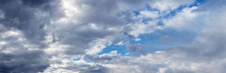 White and gray rain clouds cover the blue sky