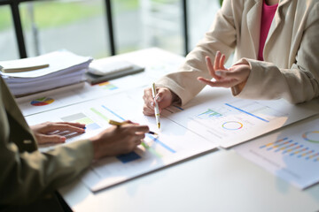 Business Meeting with Colleagues Analyzing Financial Reports and Charts in a Modern Office Setting