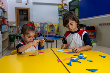 Fototapeta premium Two kids making puzzles in the school.