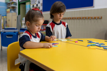 Kids playing in the school sitting in a desk.