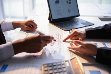 Business people meeting around a table and discussing marketing strategies using charts and a flowchart