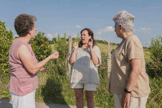 Elderly deaf women communicating using sign language outdoors