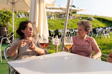Senior women enjoying a conversation over beer outdoors