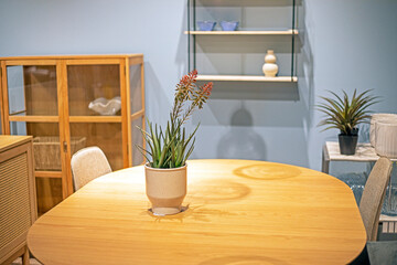 vase with decorative flowers on a round table in the interior. Modern interior