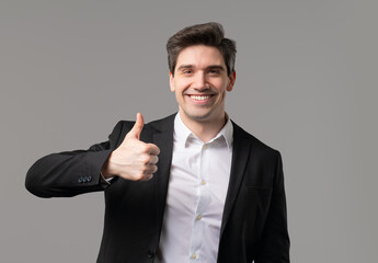 Businessman with hand sign like,thumbs up gesture. Happy ceo leader man on grey
