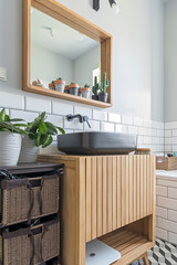 Industrial ceramic sink on wooden cabinet in design interior. Luxury in real estate. Bathroom with white tiles. Vertical.