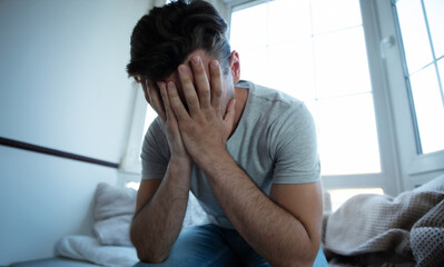 Depressed, sad, frustrated, crying, scared, instability mental and bipolar young man sitting on the...