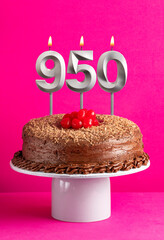 Number 950 candle - Chocolate cake on pink background