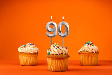 Candle number 90 - Celebration with birthday cupcake on orange background