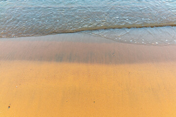 Soft wave of the sea on the sandy beach.