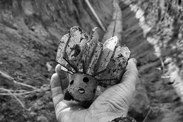 parts mortar mine in hand of a soldier. shank in hand, mortar mine tail. exploding shell. in the trench after the battle. ammunition shank. war. conflict. Russian-Ukrainian war in Donbass