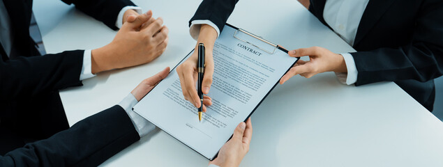 Business executive signing contract agreement document on the bale with the help from company...