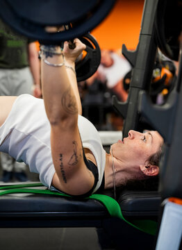 Dedicated young woman practices weightlifting in gym