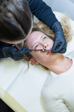 Beautician performing microblading, sketching for treatment