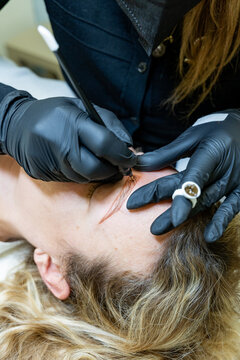 Beautician Performing Microblading on Client's Eyebrows