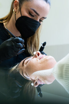 Beautician Performing Precise Microblading Procedure