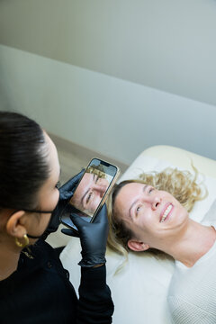 Beautician Photographing Microblading Results on Client