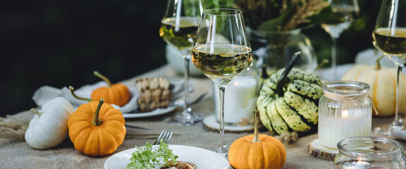 Fall table decoration with pumpkins, wine. Family thanksgiving dinner arrangement outdoors in the garden. Countryside style, simple handmade setting, autumn mood banner