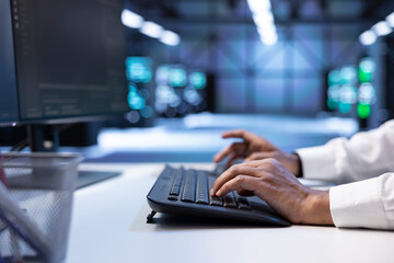 Programmer typing on keyboard, optimizing data center performance and capacity using computer. Close up of IT expert troubleshooting mainframes to ensure optimal performance and minimize downtime