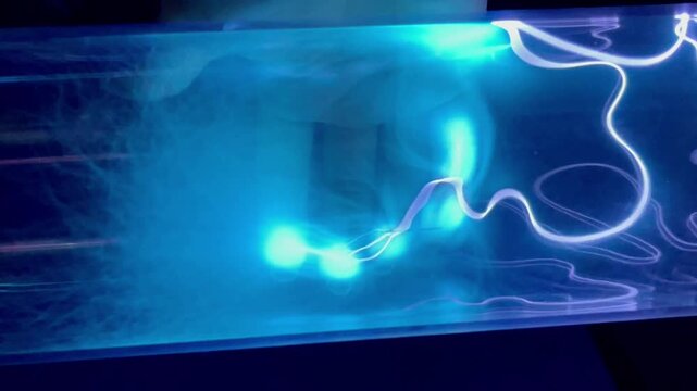 Blue neon gas discharge in plasma in transparent glass tube